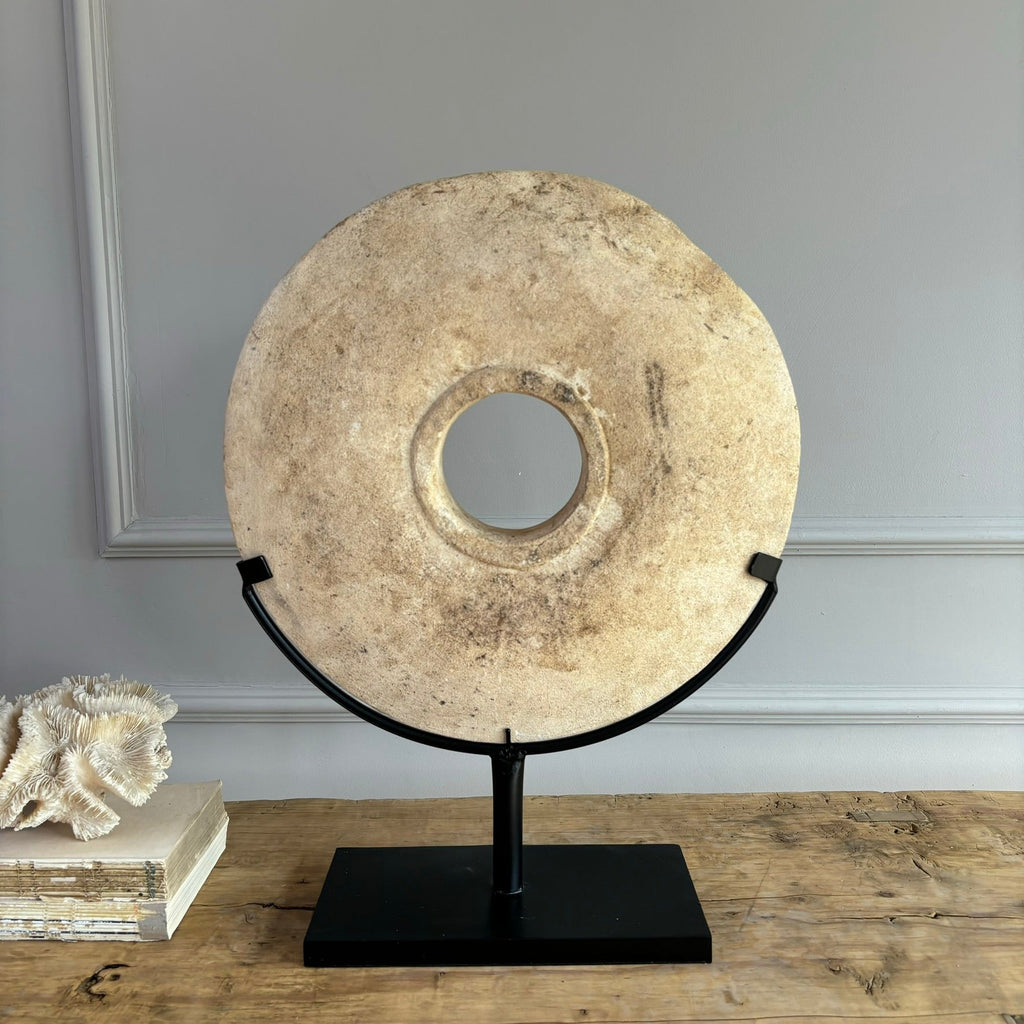Large sandstone disc on stand